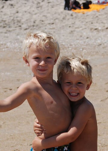 Two young boys smiling on the beach